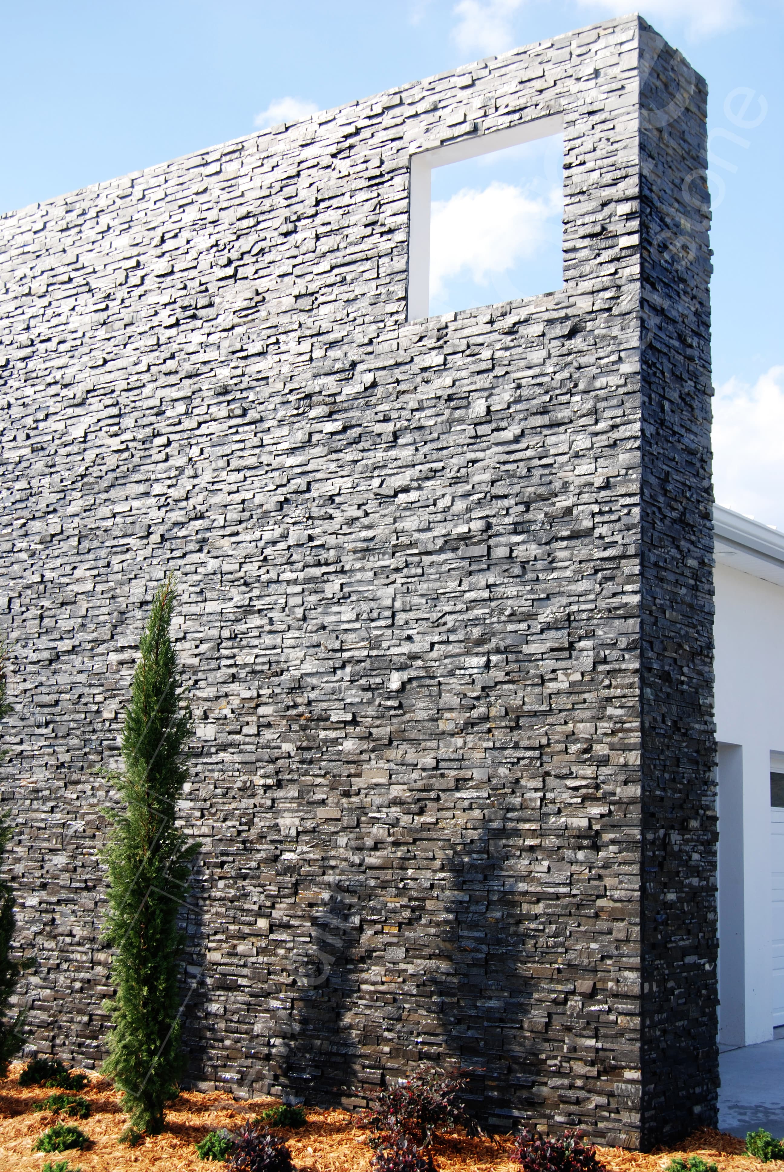 Norstone Charcoal Rock Panel thin stone veneer system used on a two story exterior feature wall in Florida